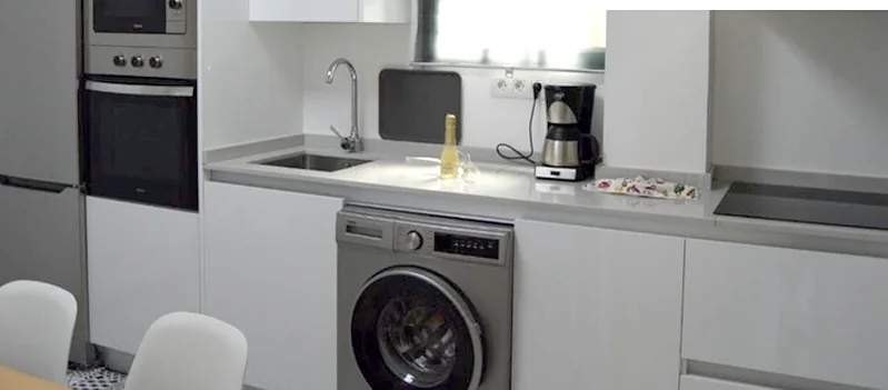 Encimera de la cocina con cafetera, vitrocerámica y lavadora
